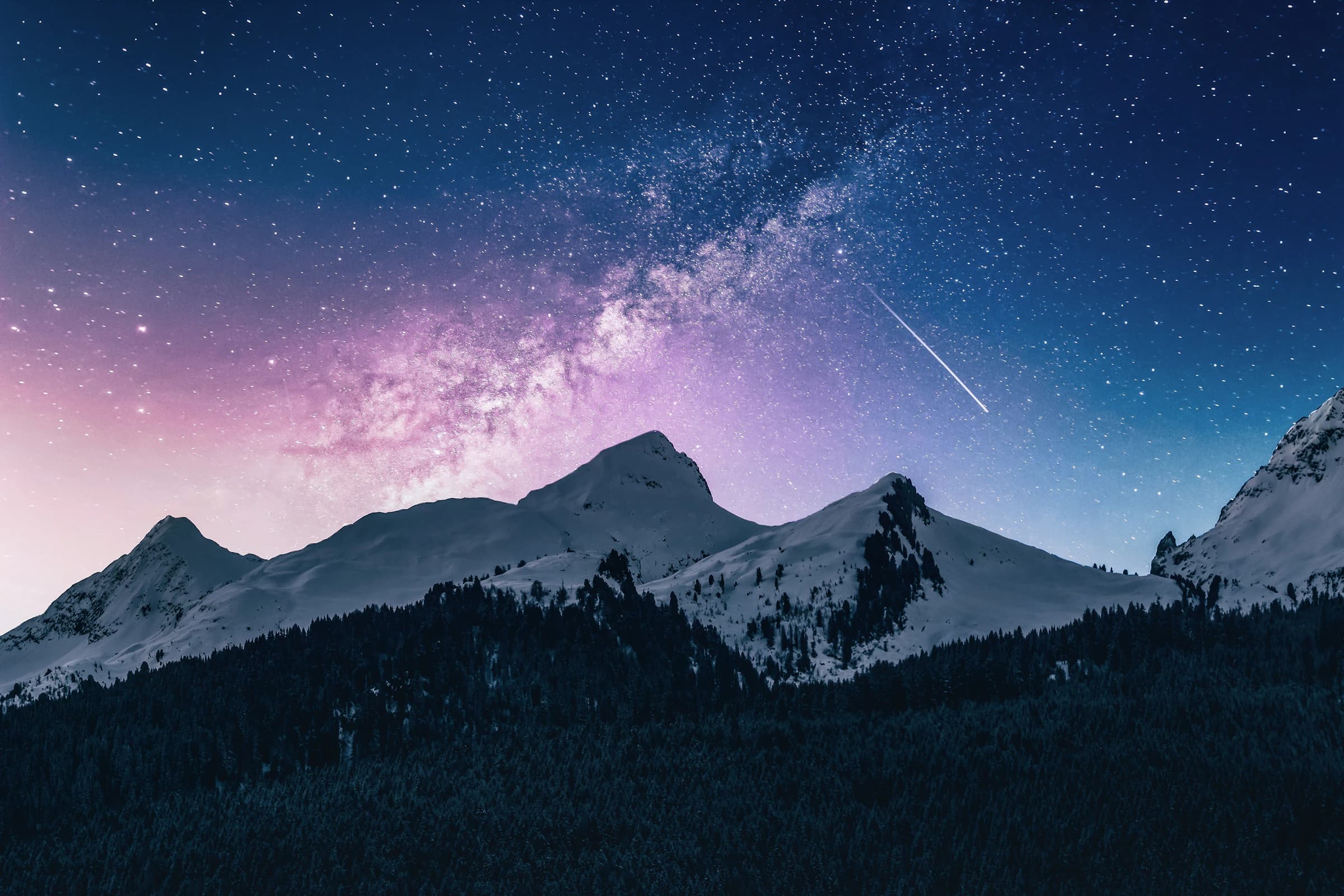 Snowed Peak under a sky full of stars, with the dark slope in the foreground