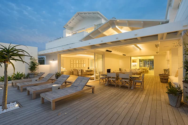 Villa terrace with sun loungers and dining pavilion at dusk